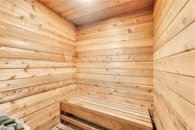 view of sauna / steam room with wooden ceiling and wood walls