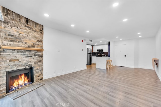 unfurnished living room with light hardwood / wood-style flooring and a fireplace