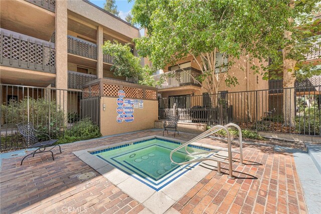 view of swimming pool with a patio and a community hot tub