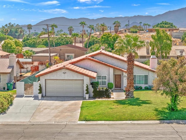 view of front facade with a mountain view, a garage, and a front yard