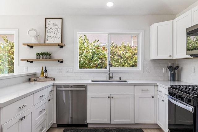 kitchen with white cabinetry, sink, stainless steel appliances, tasteful backsplash, and hardwood / wood-style flooring