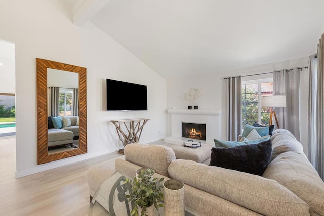 living room with a healthy amount of sunlight, beam ceiling, high vaulted ceiling, and light hardwood / wood-style flooring