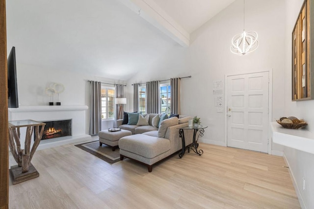 living room with beamed ceiling, high vaulted ceiling, a chandelier, and light wood-type flooring