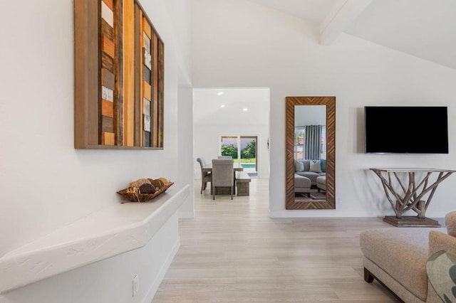 corridor with lofted ceiling with beams and light hardwood / wood-style floors