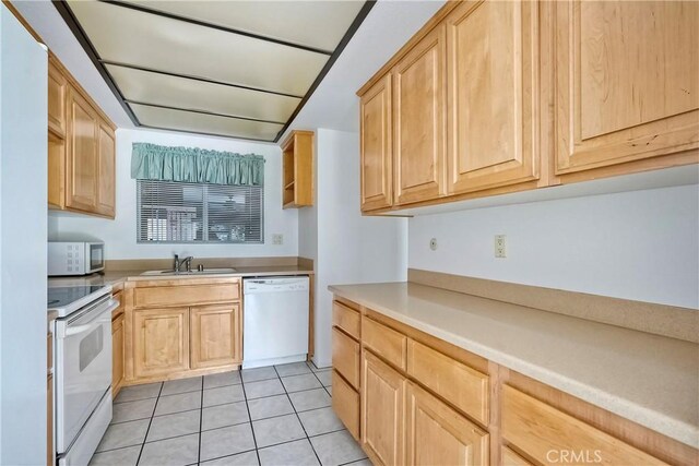 kitchen featuring light brown cabinets, light tile patterned flooring, white appliances, and sink