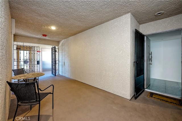 hallway featuring carpet floors and a textured ceiling