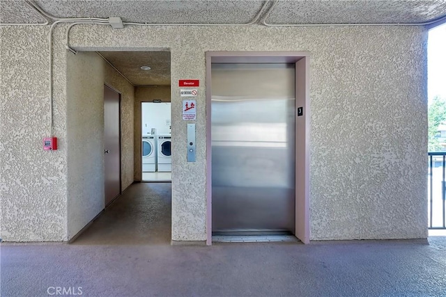 hallway with washer and dryer, elevator, and a healthy amount of sunlight