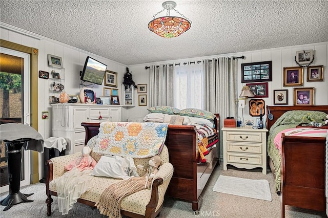 bedroom with light carpet, a textured ceiling, and wood walls