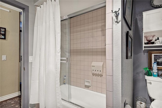 bathroom with shower / bath combination with glass door and toilet