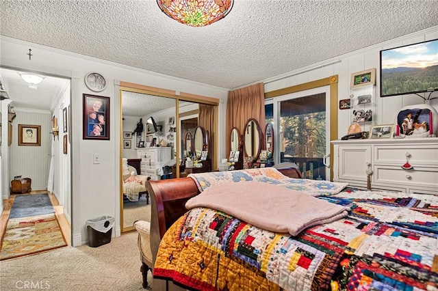 carpeted bedroom with ornamental molding, a textured ceiling, and access to outside