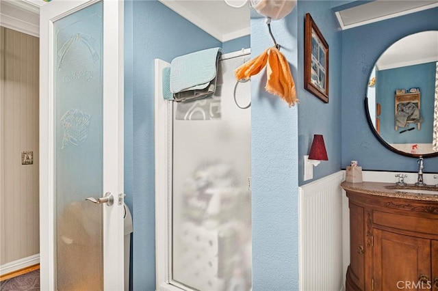 bathroom featuring vanity, walk in shower, and crown molding