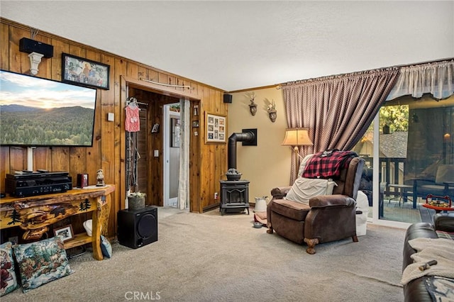 179 Golf Course Rd, Lake Arrowhead, CA 92317 - living area featuring a wood stove, wooden walls, carpet, and crown molding