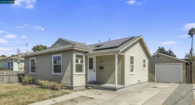 view of front of house with solar panels, a garage, and an outdoor structure