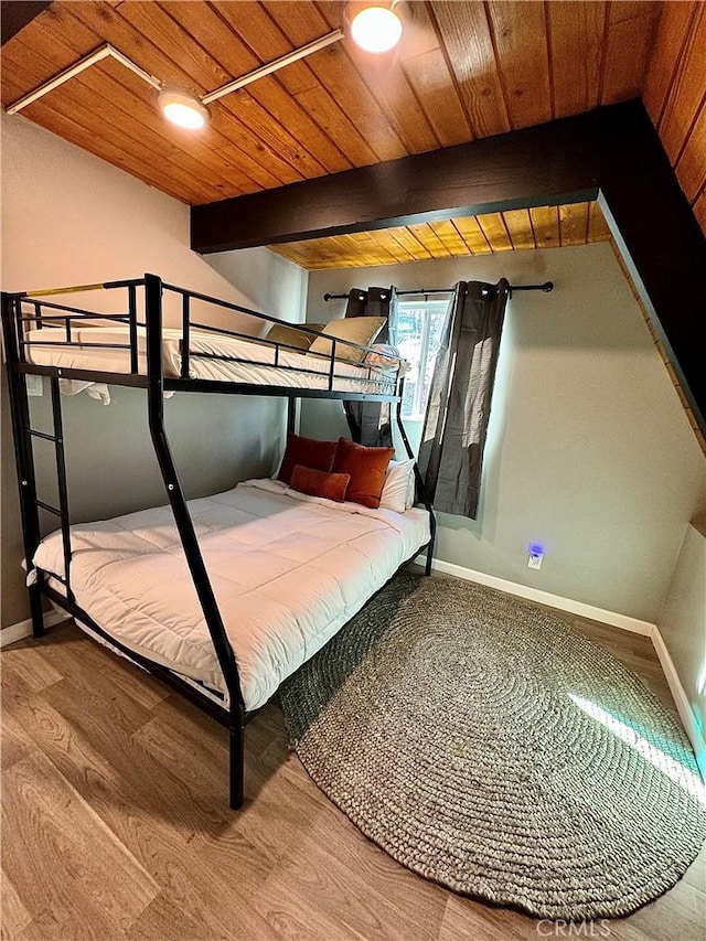 bedroom with hardwood / wood-style flooring, beam ceiling, and wooden ceiling