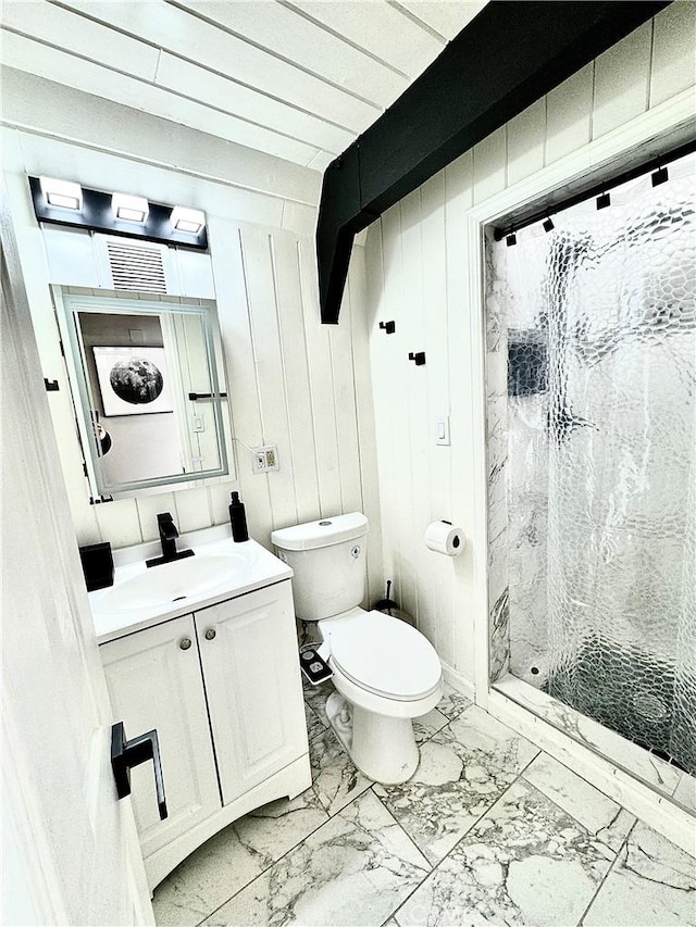 bathroom with a shower, wooden walls, vanity, and toilet