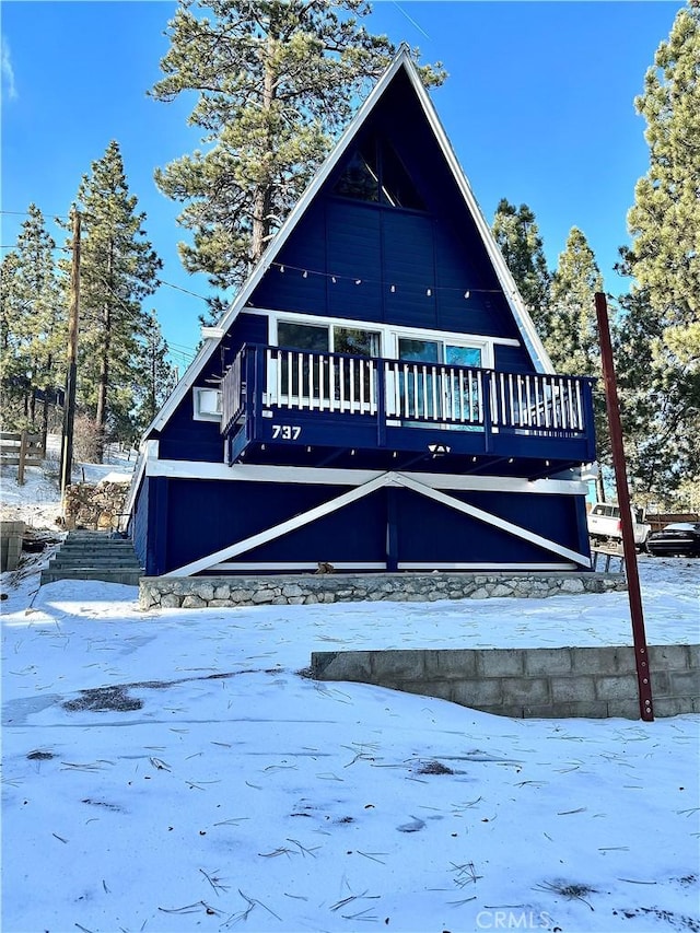 snow covered property featuring a wooden deck