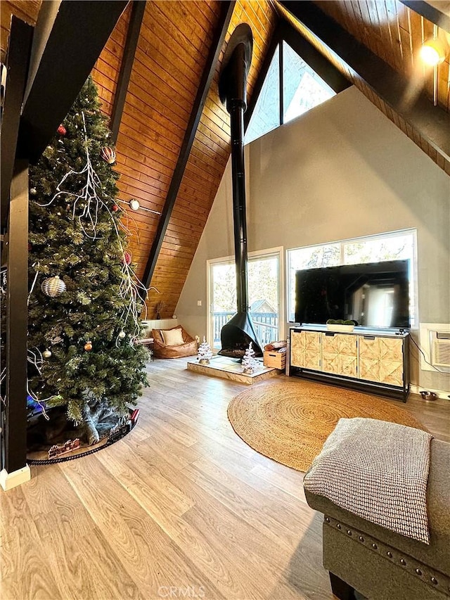 living room featuring beamed ceiling, wood-type flooring, high vaulted ceiling, and wood ceiling