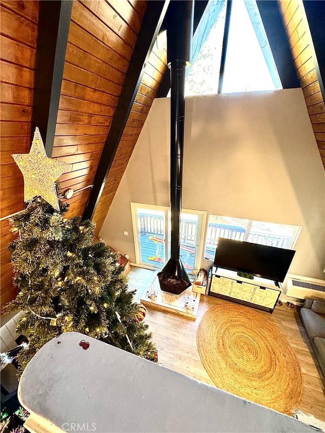 details with wooden ceiling, a wood stove, hardwood / wood-style flooring, a baseboard radiator, and beam ceiling