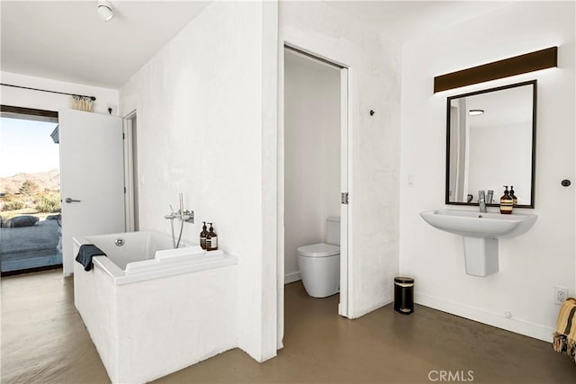 bathroom featuring concrete floors, toilet, and a bathtub