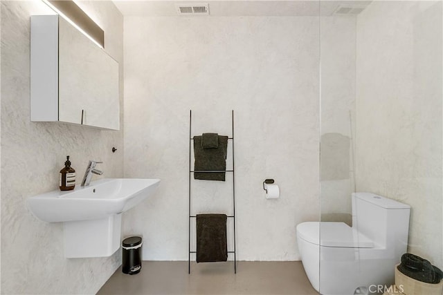 bathroom featuring concrete flooring and toilet