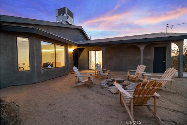 patio terrace at dusk with an outdoor fire pit and cooling unit