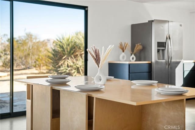 kitchen featuring stainless steel fridge with ice dispenser and a kitchen island