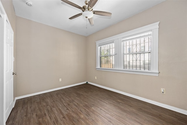 empty room with ceiling fan and dark hardwood / wood-style flooring