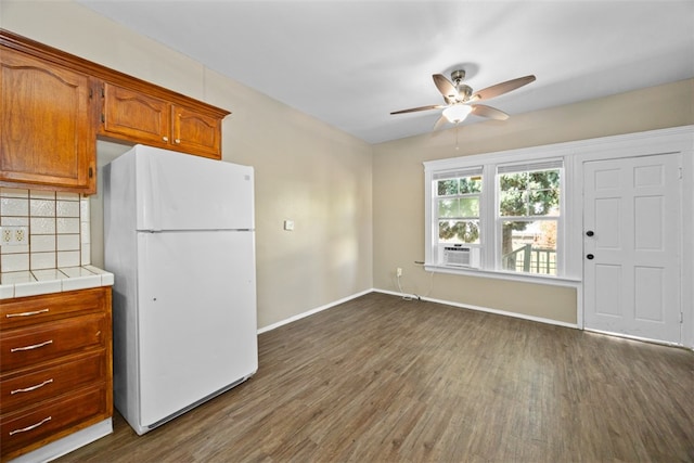 kitchen with ceiling fan, white refrigerator, tile countertops, and dark hardwood / wood-style flooring