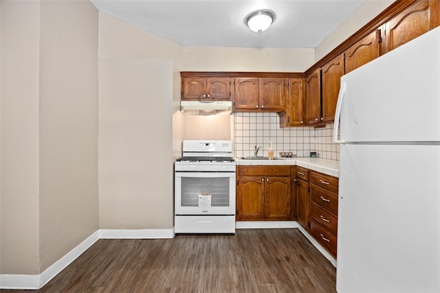 kitchen with decorative backsplash, white appliances, dark hardwood / wood-style flooring, and sink