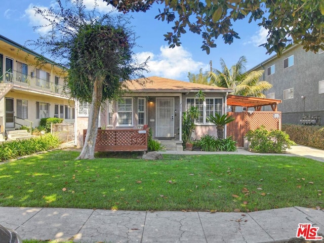 view of front of home with a balcony and a front lawn