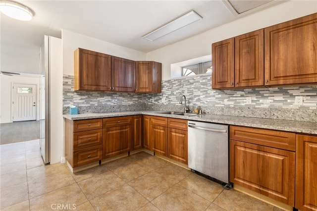 kitchen featuring decorative backsplash, stainless steel dishwasher, sink, and light stone counters