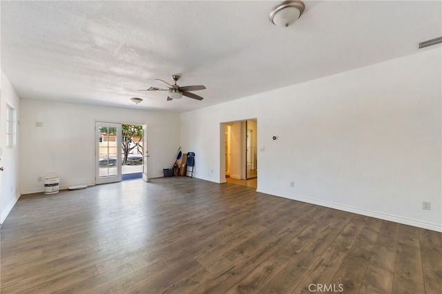 empty room featuring ceiling fan, dark wood-type flooring, and a textured ceiling