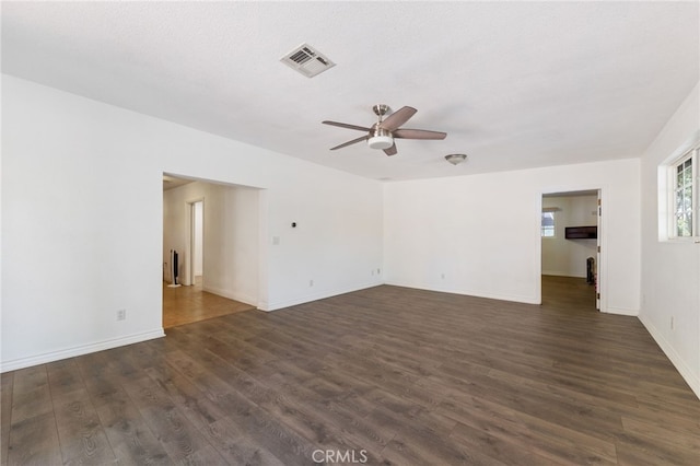 empty room featuring ceiling fan, a textured ceiling, and dark hardwood / wood-style floors