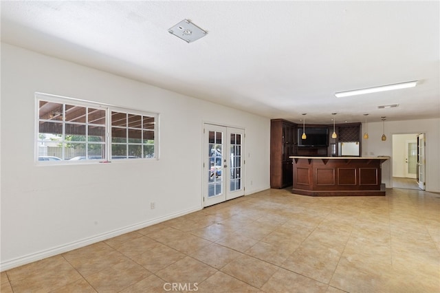 unfurnished living room featuring french doors and light tile patterned floors