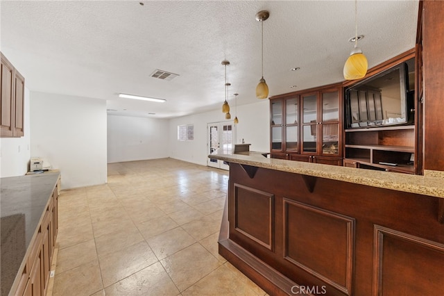 kitchen with a textured ceiling and hanging light fixtures