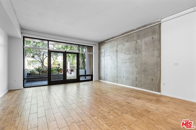 unfurnished room with light wood-type flooring and french doors