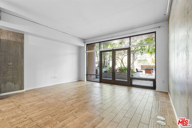 unfurnished room featuring french doors and light hardwood / wood-style floors