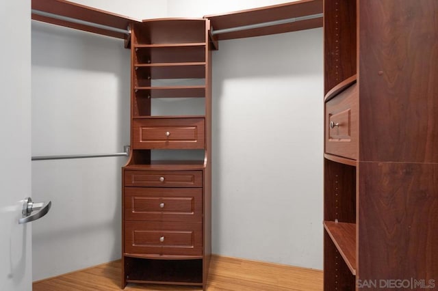 walk in closet with light hardwood / wood-style flooring