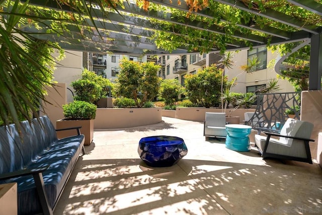 view of patio / terrace with a pergola and an outdoor living space with a fire pit