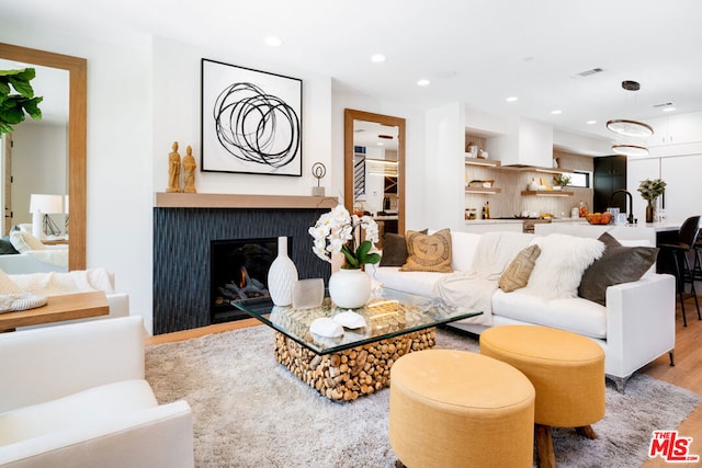 living room featuring sink and hardwood / wood-style flooring