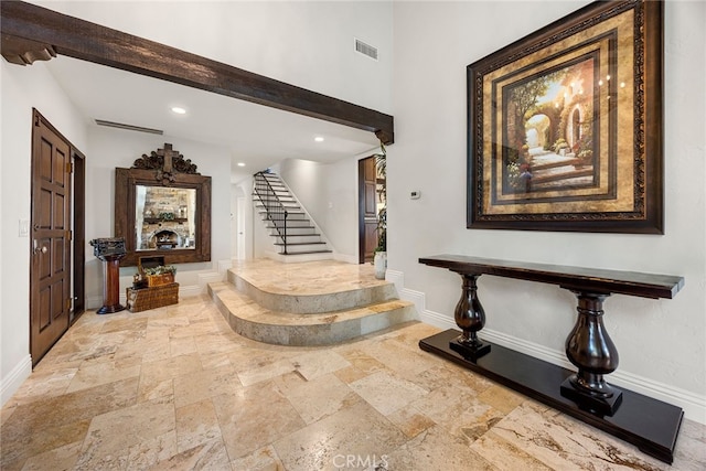 foyer with a fireplace and beamed ceiling