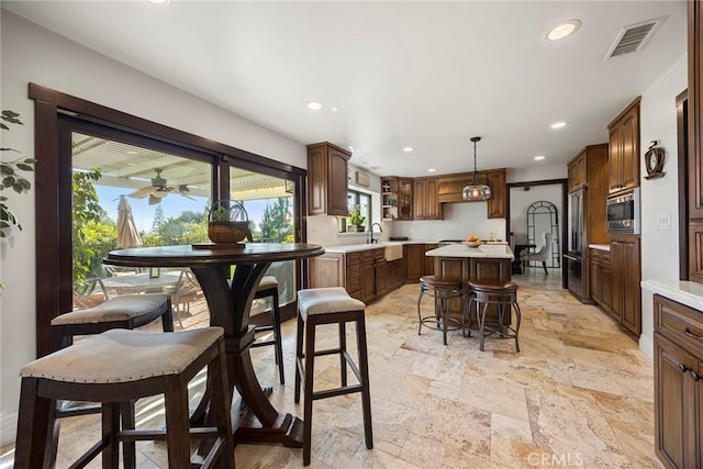 dining space featuring ceiling fan and sink