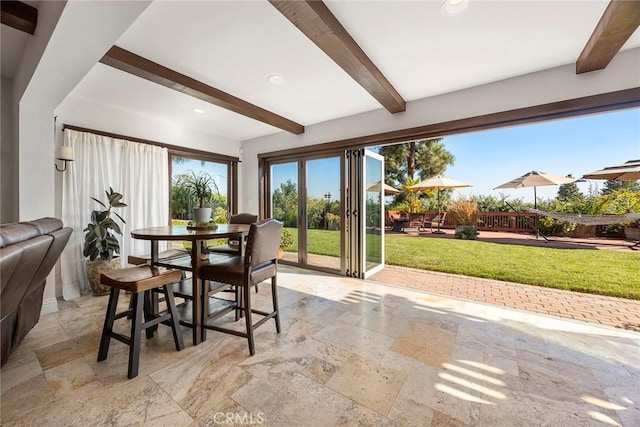 dining space with beam ceiling