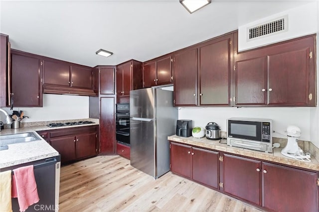 kitchen featuring sink, appliances with stainless steel finishes, and light hardwood / wood-style flooring