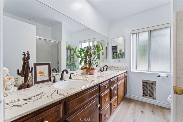 bathroom with hardwood / wood-style floors, vanity, an enclosed shower, and toilet