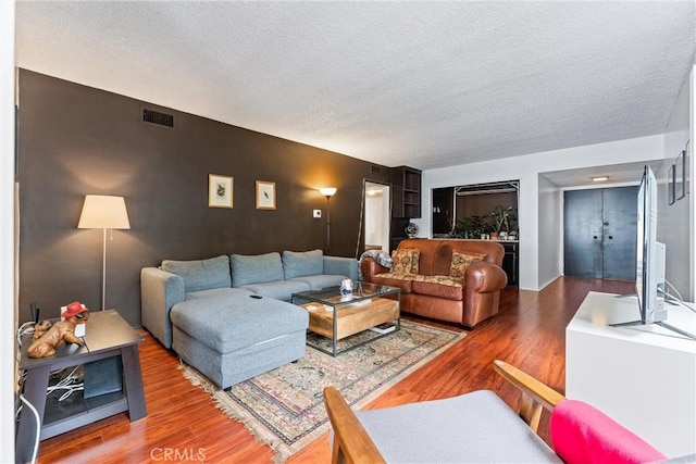 living room featuring wood-type flooring and a textured ceiling