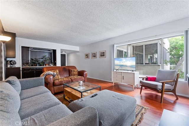 living room with wood-type flooring and a textured ceiling