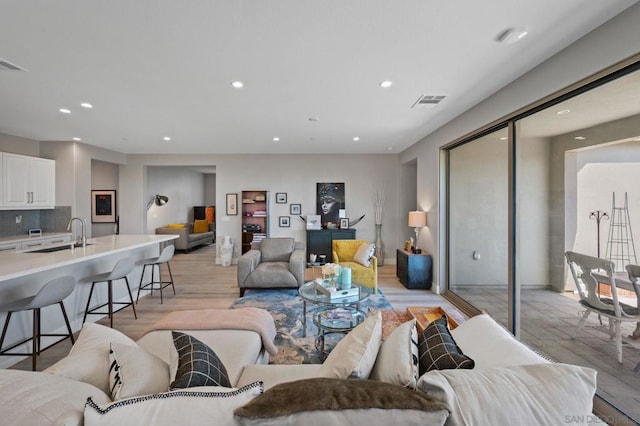 living room featuring sink and light hardwood / wood-style flooring