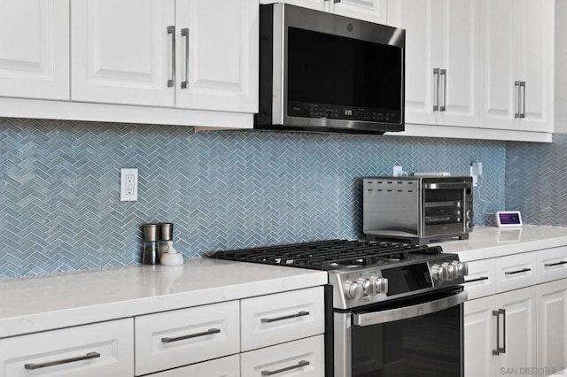 kitchen with stainless steel appliances, white cabinets, and tasteful backsplash