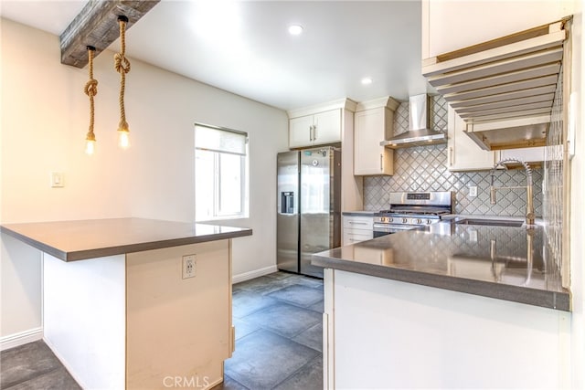 kitchen with kitchen peninsula, tasteful backsplash, wall chimney range hood, white cabinetry, and stainless steel appliances